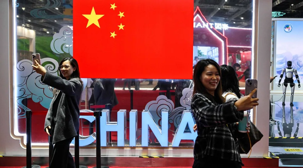 يلتقط الزوار صوراً بجناح الصين خلال معرض الاستيراد الدولي الثامن في شنغهاي (أ.ف.ب)