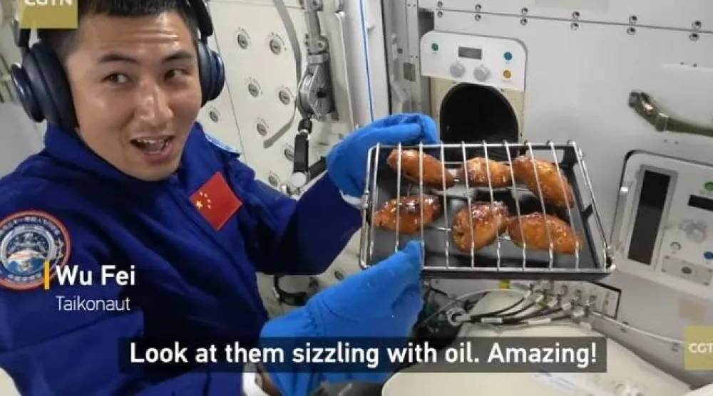 رائد الفضاء وو في وصف أجنحة الدجاج المطبوخة حديثاً بأنها «ذات اللون والرائحة والنكهة المثالية» (يوتيوب)