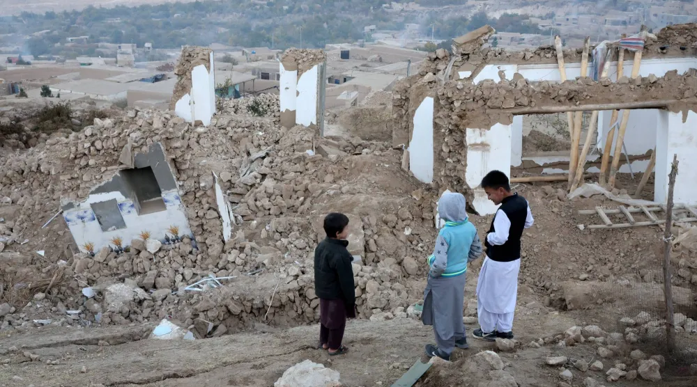 أولاد واقفون بجوار حطام المنازل المتضررة في أعقاب زلزال وقع مؤخراً بمنطقة مرمول في ولاية بلخ بأفغانستان يوم 5 نوفمبر 2025 (رويترز)