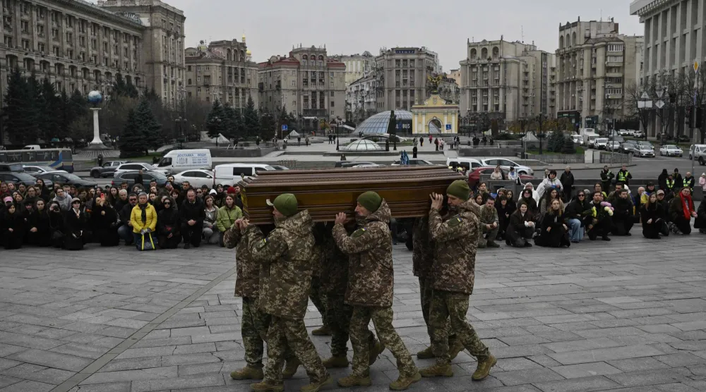  جنود من حرس الشرف يحملون نعش الجندي الأوكراني (أ.ف.ب)
