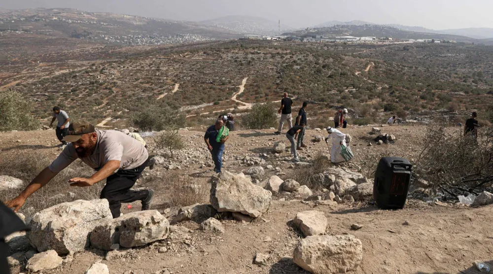 فلسطينيون يفرون من قنابل غاز أطلقها الجيش الإسرائيلي نحوهم بعد احتجاجهم أمس على مصادرة المستوطنين لأراضيهم شرق نابلس بالضفة الغربية المحتلة (أ.ف.ب)