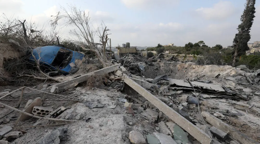 سيارة متضررة ملقاة وسط الأنقاض تظهر في موقع استهدفه الجيش الإسرائيلي بقضاء صور بجنوب لبنان (إ.ب.أ)