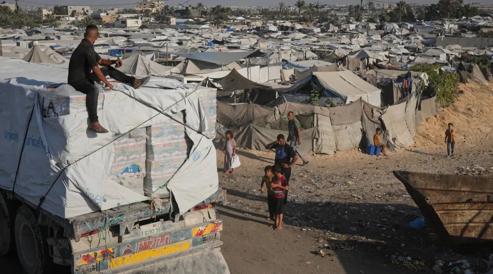 شاحنات تحمل مساعدات إنسانية تمر عبر خان يونس جنوب قطاع غزة (أ.ب)