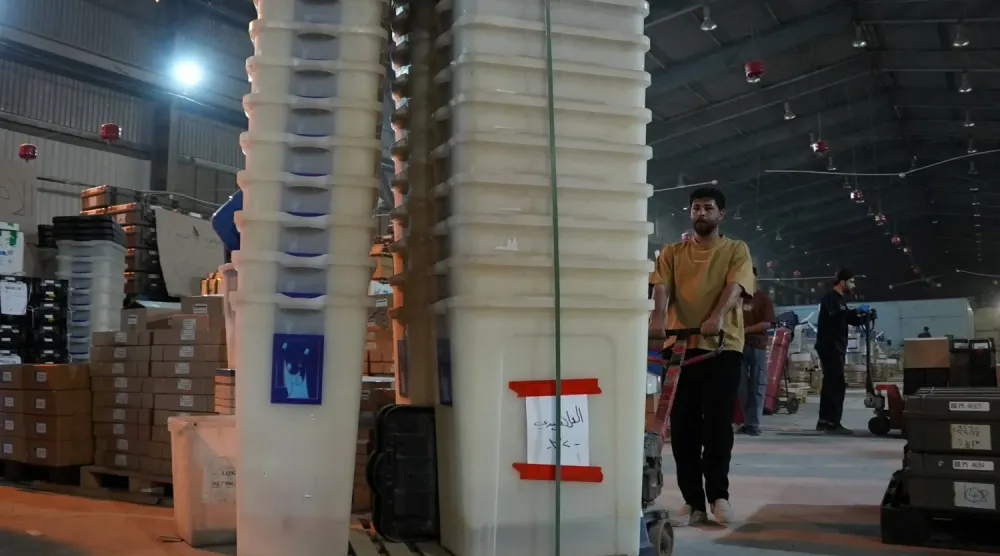  Irak Bağımsız Seçim Komisyonu çalışanları, oy kullanma hazırlıkları kapsamında sandıkları taşıyor. (Reuters)