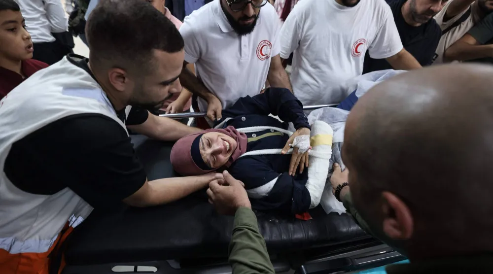 المصورة الفلسطينية رنين صوافطة أثناء حملها على نقالة في مستشفى رفيديا بنابلس بعد أن أصيبت على يد مستوطنين إسرائيليين في قرية بيتا الفلسطينية (أ.ف.ب)