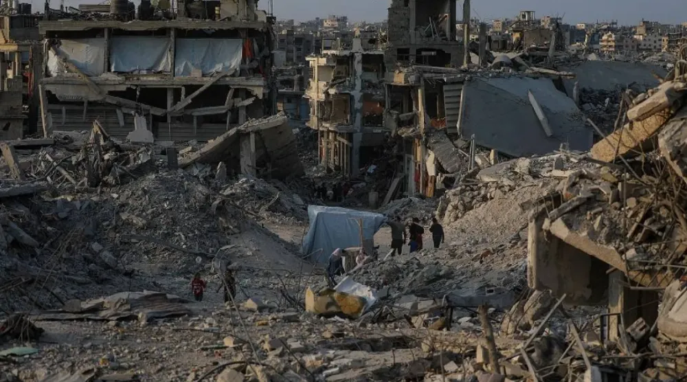Palestinians move between destroyed buildings in Jabaliya, northern Gaza Strip, 04 November 2025, amid a ceasefire between Israel and Hamas. (EPA)
