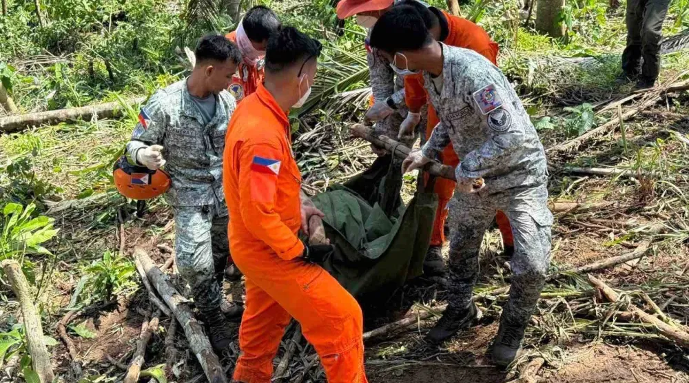 أفراد من القوات الجوية الفلبينية يحملون رفات طاقم مروحية بعد تحطمها أثناء قيامها بأعمال إغاثة خلال الإعصار كالمايغي (أ.ب)