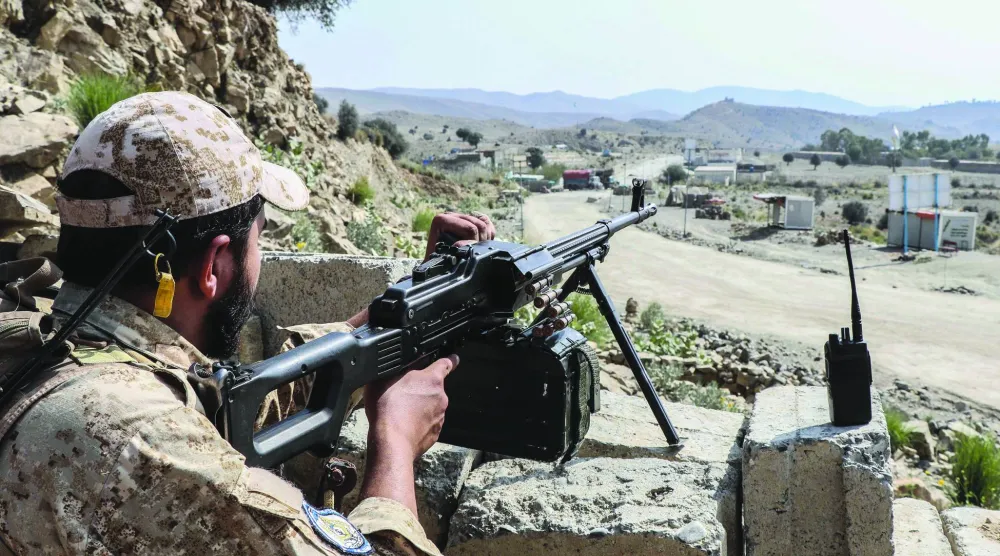 يقف أحد عناصر أمن «طالبان» حارساً على طريق قرب معبر غلام خان الحدودي بين أفغانستان وباكستان (أ.ف.ب)