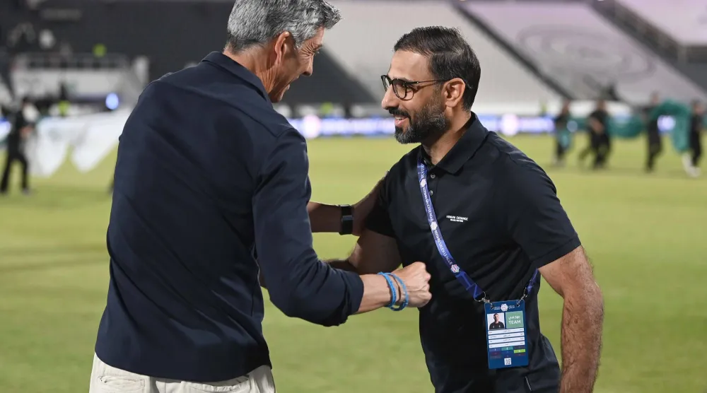 تحية متبادلة بين سعد الشهري مدرب الاتفاق وألغواسيل مدرب الشباب (تصوير: عبد الرحمن السالم)