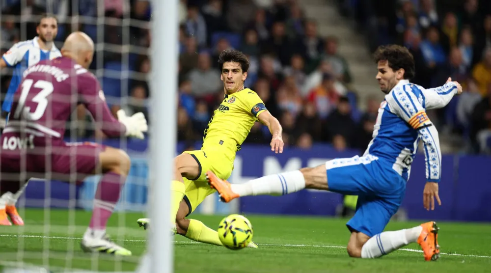 الإسباني جيرارد مورينو مهاجم فياريال يحاول افتكاك الكرة من الحارس الصربي ماركو ديميتروفيتش لاعب إسبانيول (أ.ف.ب).