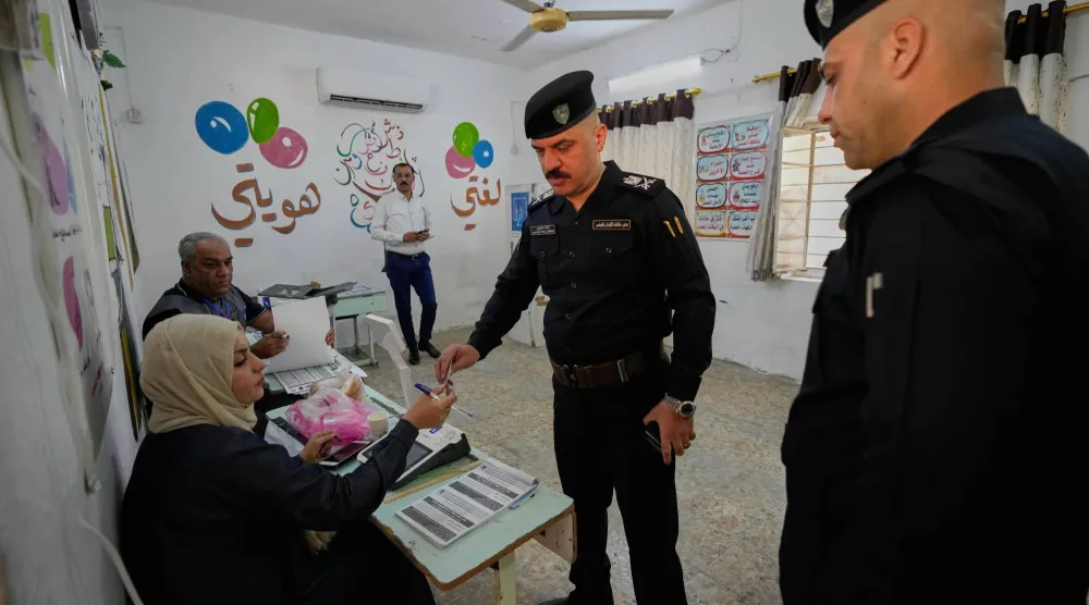شرطي عراقي يدلي بصوته خلال التصويت المبكر للقوات الأمنية (أ.ب)