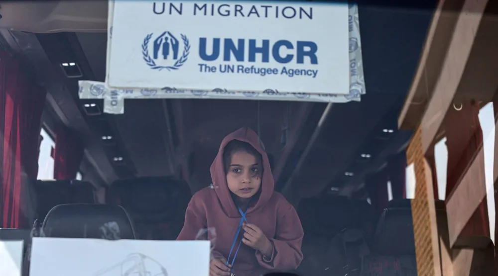 طفلة على متن حافلة تقل لاجئين سوريين خلال رحلة عودتهم من لبنان الخميس الماضي (إ.ب.أ)