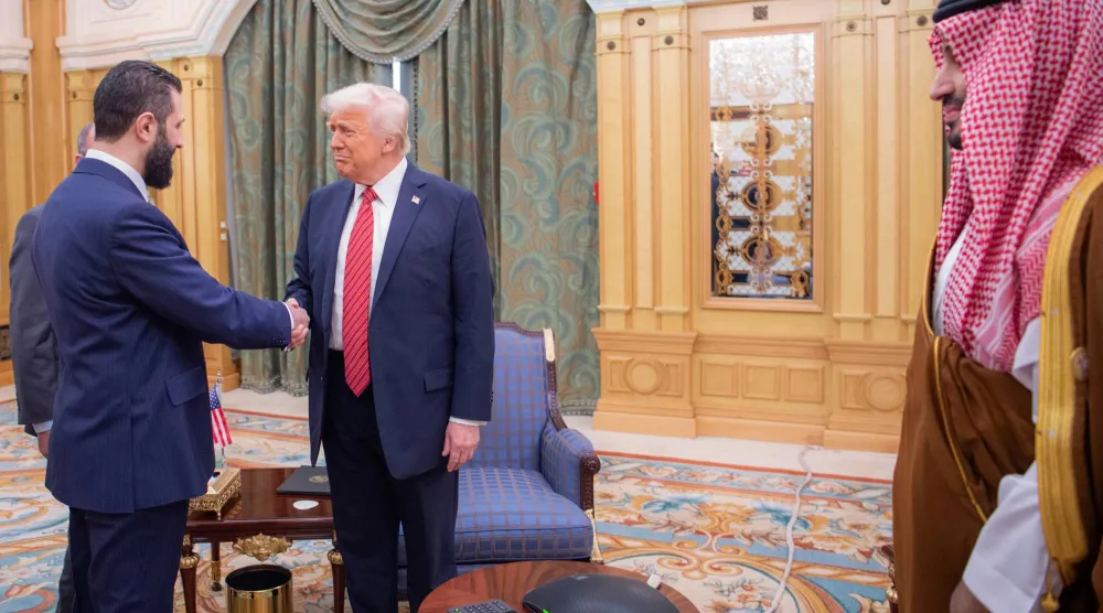 الرئيس السوري أحمد الشرع يصافح الرئيس الأميركي دونالد ترمب في الرياض 14 مايو وعلى اليمين ولي العهد السعودي الأمير محمد بن سلمان (أ.ب)