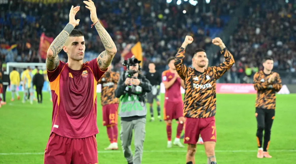 لاعبو روما يحتفلون بالفوز على أودينيزي (أ.ف.ب)