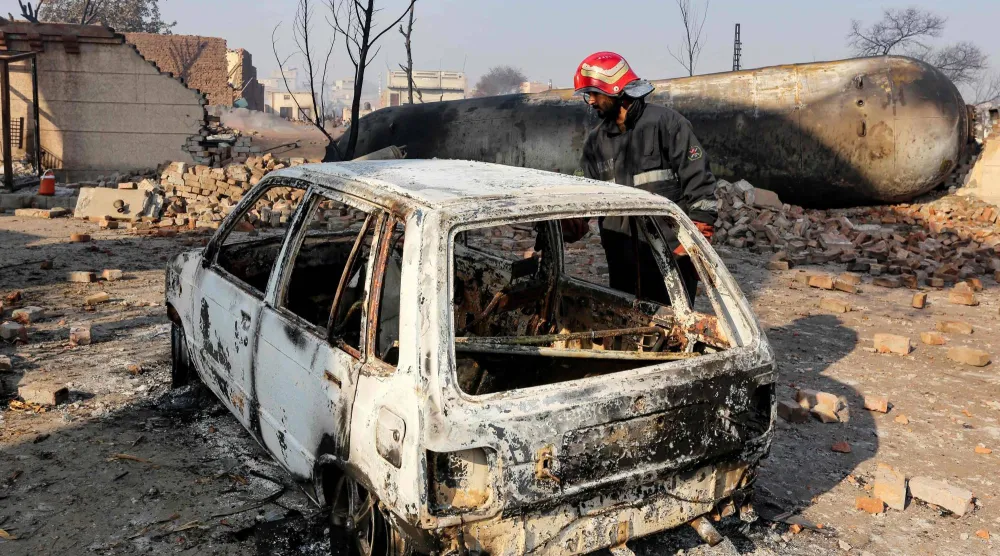 أحد أفراد الإنقاذ يفحص سيارة متفحمة بعد انفجار شاحنة صهريج في ملتان بباكستان (أرشيفية - أ.ف.ب)