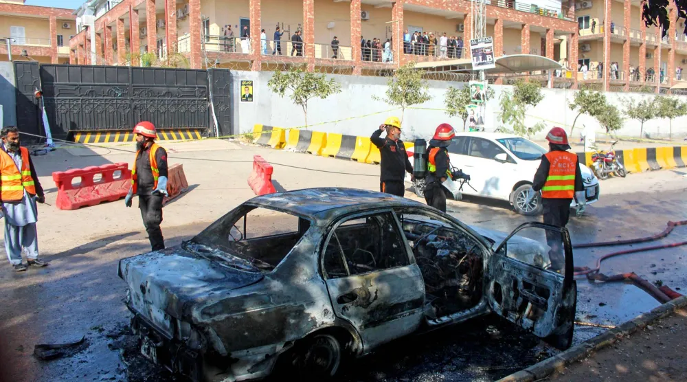 رجال الإطفاء يُخمدون حريقاً في سيارة بموقع التفجير الانتحاري بإسلام آباد (أ.ف.ب)