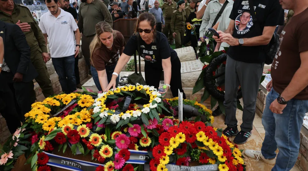 مشيعون يضعون إكليلاً على نعش الضابط هَدار غولدِن في كفار سابا (أ.ب)