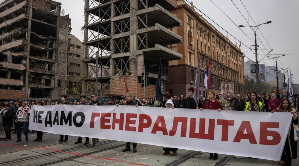 أشخاص يشاركون في احتجاج أمام مقر سابق للجيش بسبب قانون جديد لتسريع تحويله إلى مجمع فاخر يرتبط بشركة استثمارية أسسها صهر الرئيس الأميركي دونالد ترمب في بلغراد (رويترز)