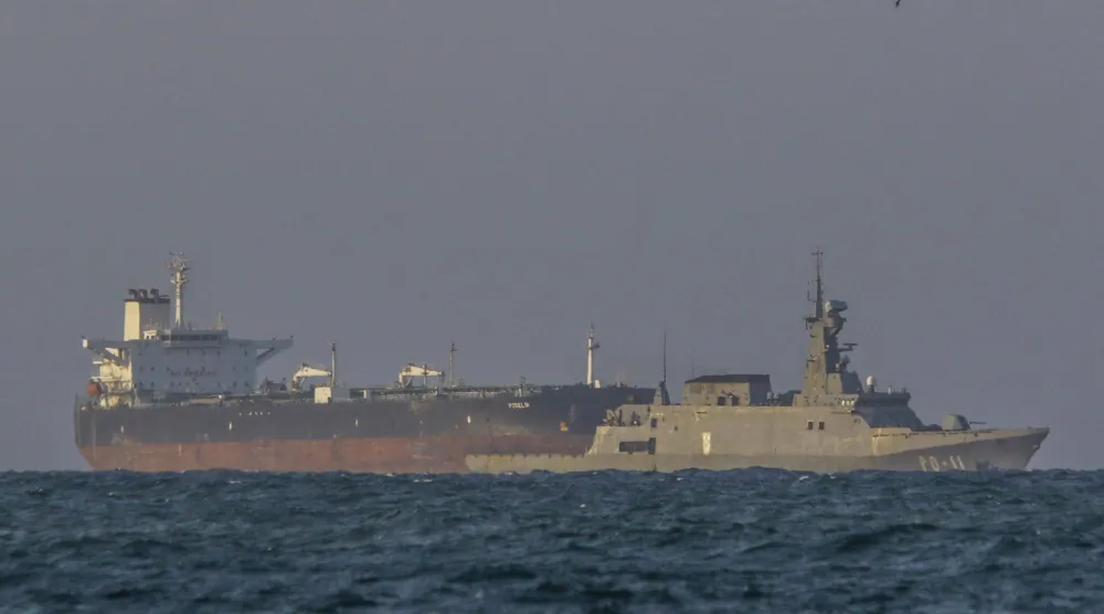 زورق دورية تابع للبحرية الفنزويلية يرافق ناقلة النفط الخام «يوسلين" التي ترفع علم بنما بالقرب من مصفاة إل باليتو في بويرتو كابيلو (أ.ف.ب)