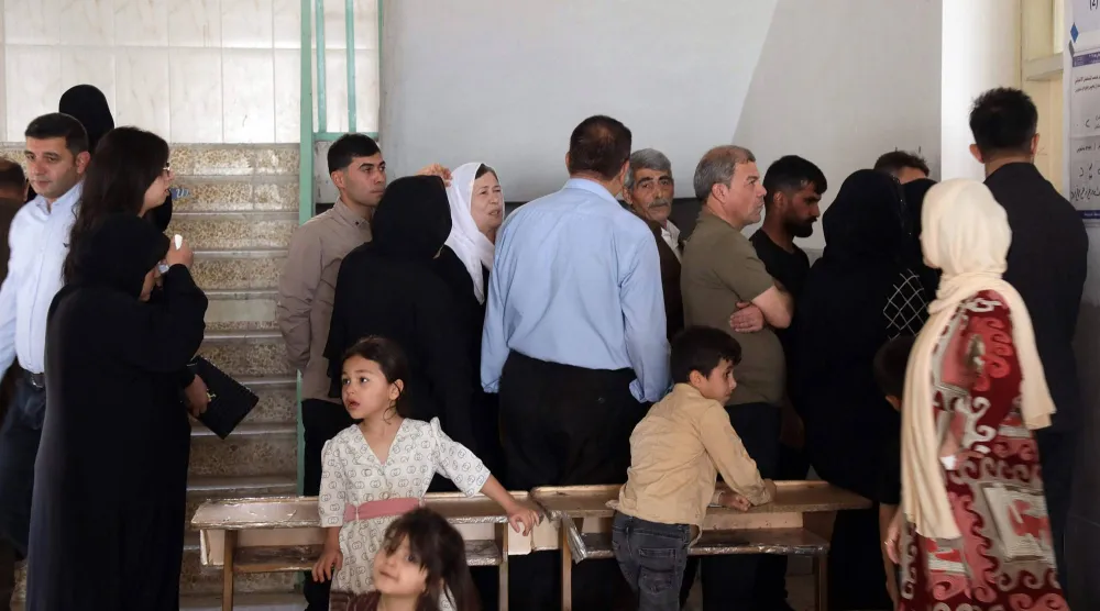 ناخبون في طابور داخل أحد مراكز الاقتراع في مدينة عقرة شمال أربيل في إقليم كردستان العراق (أ.ف.ب)