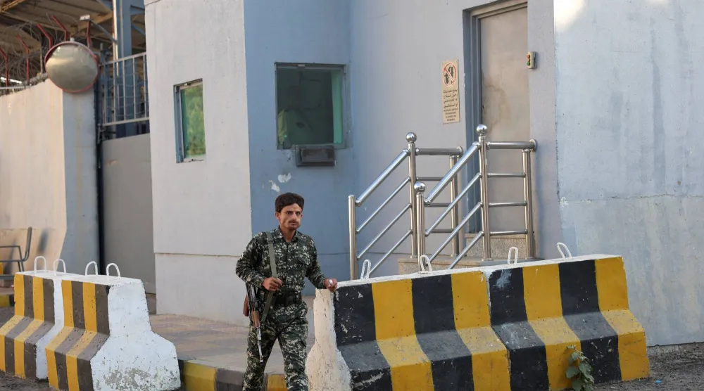 عنصر حوثي أمام مبنى أممي في صنعاء اقتحمته الجماعة (رويترز)