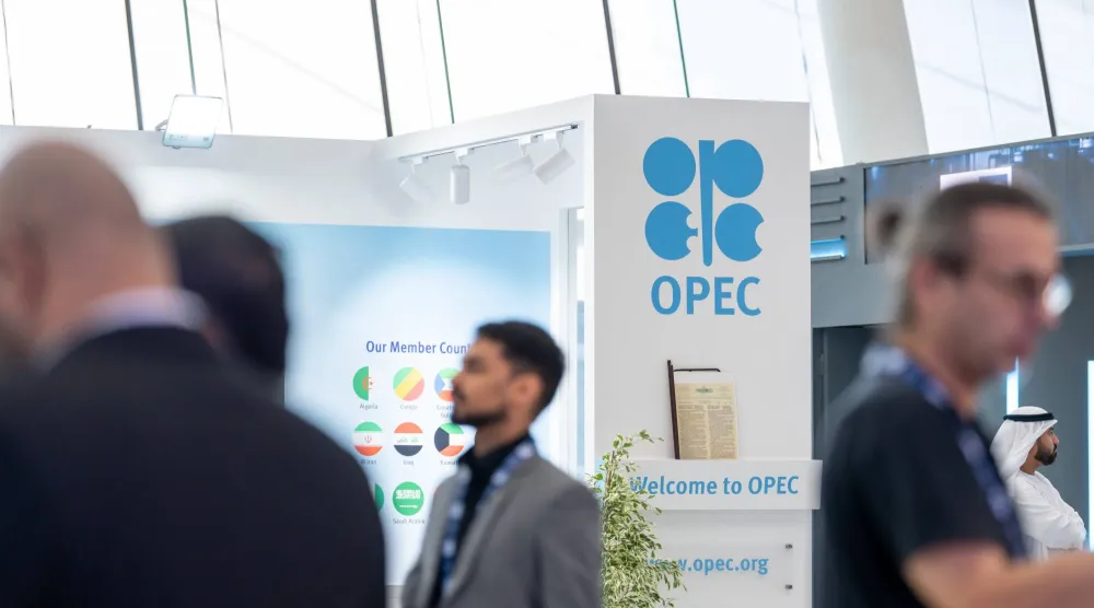 أشخاص يقفون إلى جانب جناح «أوبك» في مؤتمر «أديبك» (إكس)