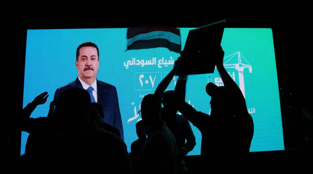 شاشة تحمل ملصقاً انتخابياً لرئيس الوزراء الحالي محمد شياع السوداني (رويترز)