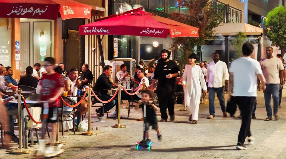 يستمتع الناس بالجلوس في الهواء الطلق مع انحسار حرارة الصيف في الرياض (أ.ف.ب)