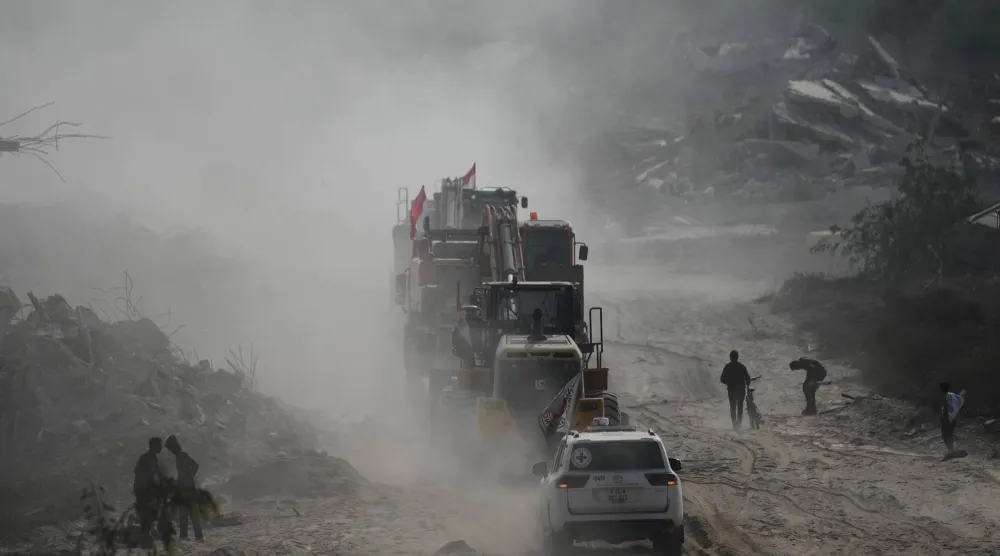 مسلحون من «حماس» وعمال مصريون برفقة عناصر من الصليب الأحمر يتوجهون إلى شرق مدينة غزة للبحث عن جثث الرهائن اليوم الخميس (أ.ب)