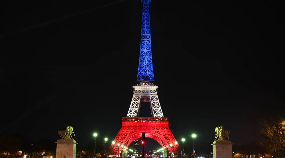 برج إيفل مضاء بألوان العلم الفرنسي تكريماً لضحايا الهجمات الإرهابية بباريس الأربعاء (د.ب.أ)