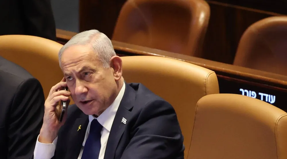  رئيس الوزراء الإسرائيلي بنيامين نتنياهو يتحدث في الهاتف خلال حضور جلسة في الكنيست (إ.ب.أ) 