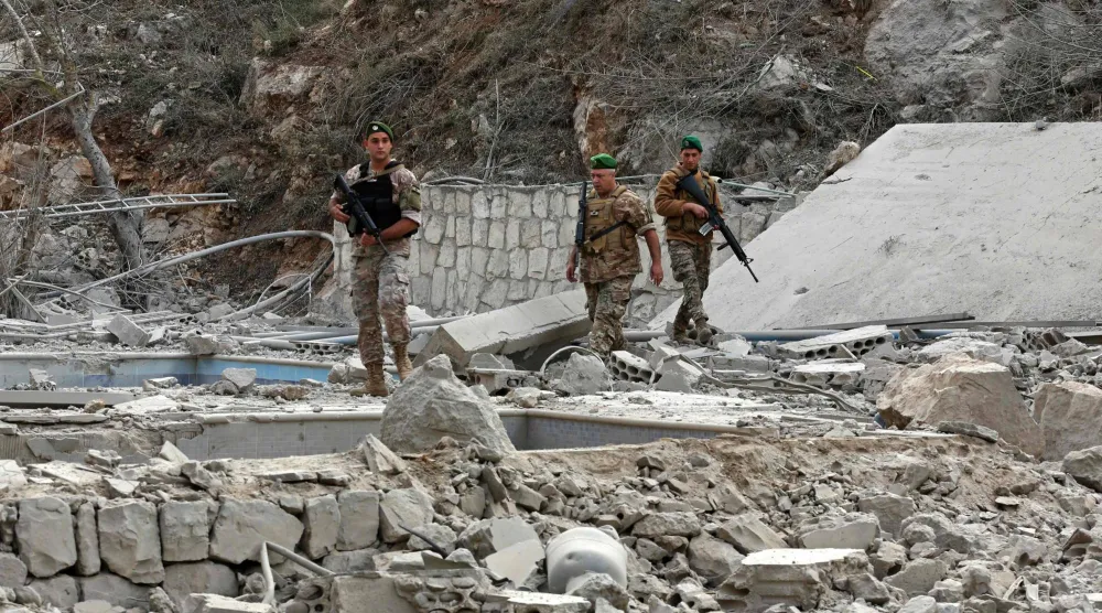 جنود تابعون للجيش اللبناني يتفقدون موقع غارة إسرائيلية في قرية طير فلساي بالقرب من الليطاني في جنوب لبنان أمس (أ.ف.ب) 