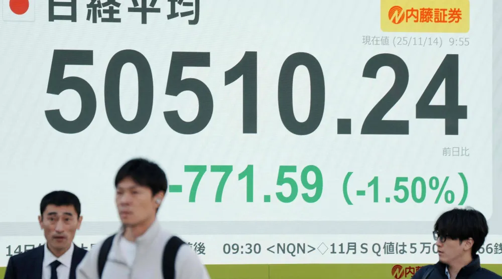 مشاة يعبرون أمام شاشة تعرض حركة الأسهم في وسط العاصمة اليابانية طوكيو (أ.ف.ب)