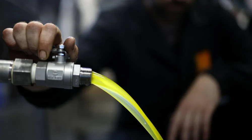 رجل يعمل داخل مصنع لإنتاج زيت الزيتون في جنوب فرنسا (إ.ب.أ)