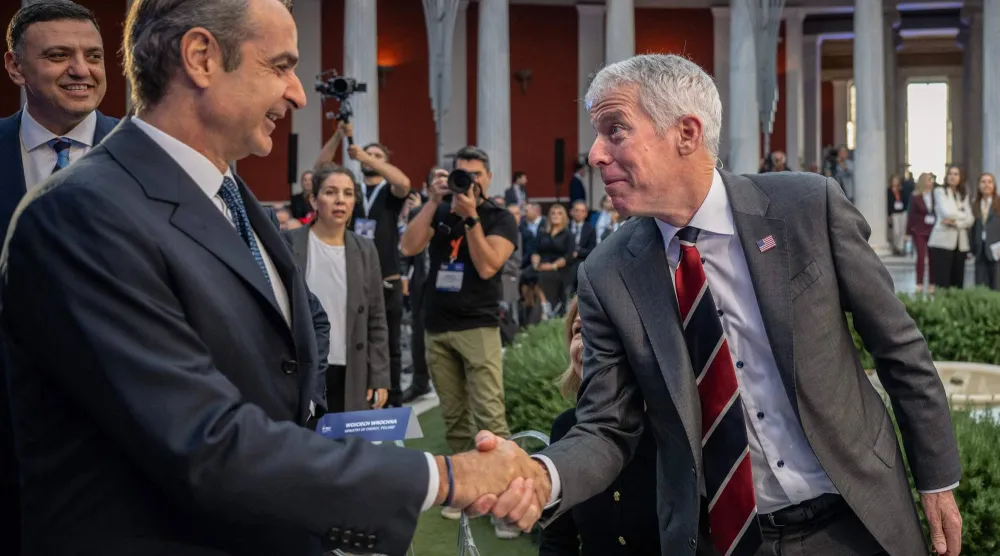 رئيس الوزراء اليوناني كيرياكوس ميتسوتاكيس يصافح رايت خلال اجتماع التعاون في مجال الطاقة عبر الأطلسي (أ.ف.ب)