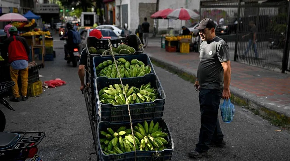  A man pushes a hand truck loaded with plantains through La Candelaria neighborhood in Caracas on November 13, 2025. (AFP) 