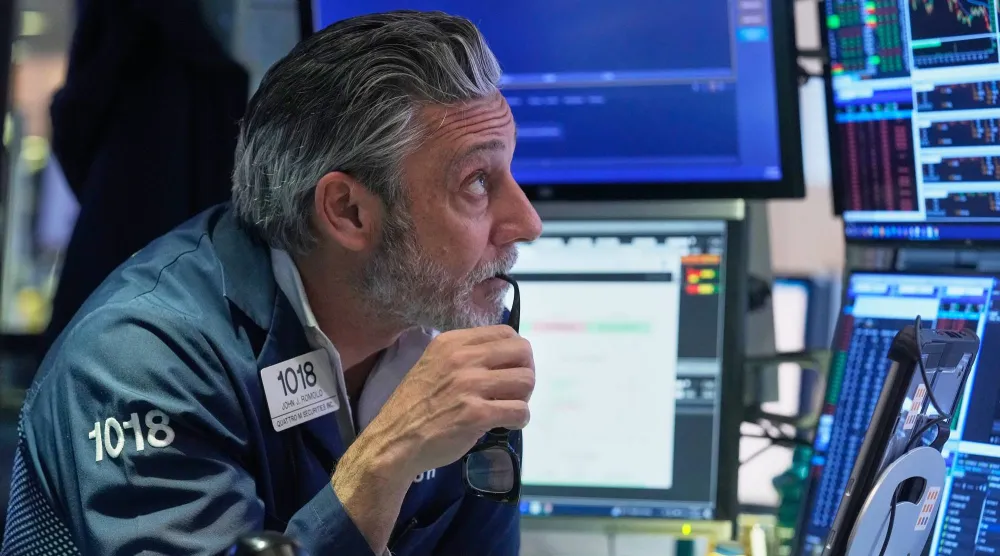 متداول ينظر إلى شاشات تعرض مؤشرات الأسهم في بورصة نيويورك (أ.ب)