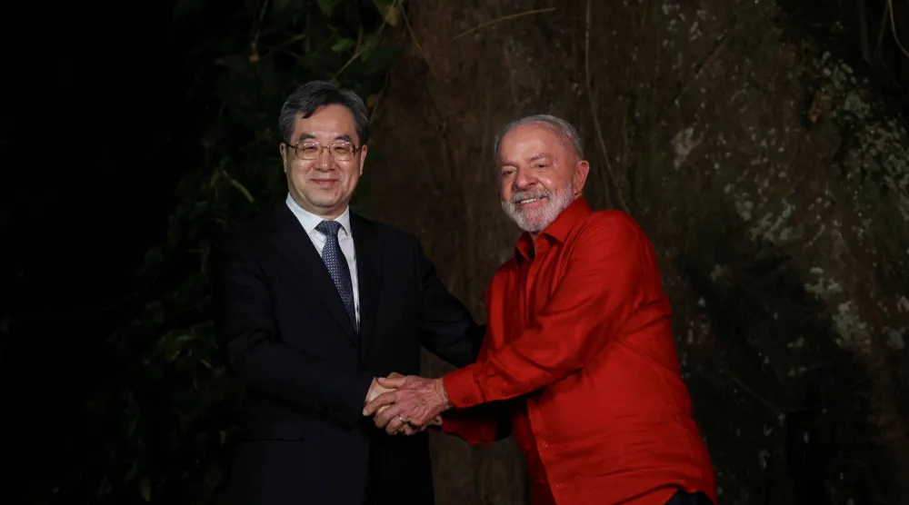 الرئيس البرازيلي لويس إيناسيو لولا دا سيلفا يصافح نائب رئيس الوزراء الصيني دينغ شيويه شيانغ قبل مؤتمر الأمم المتحدة لتغير المناخ في بيليم (رويترز)