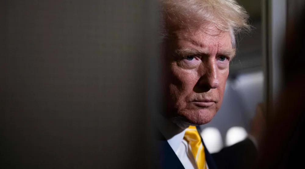 الرئيس دونالد ترمب يتحدث إلى الصحافيين على متن طائرة الرئاسة أمس (أ.ف.ب)