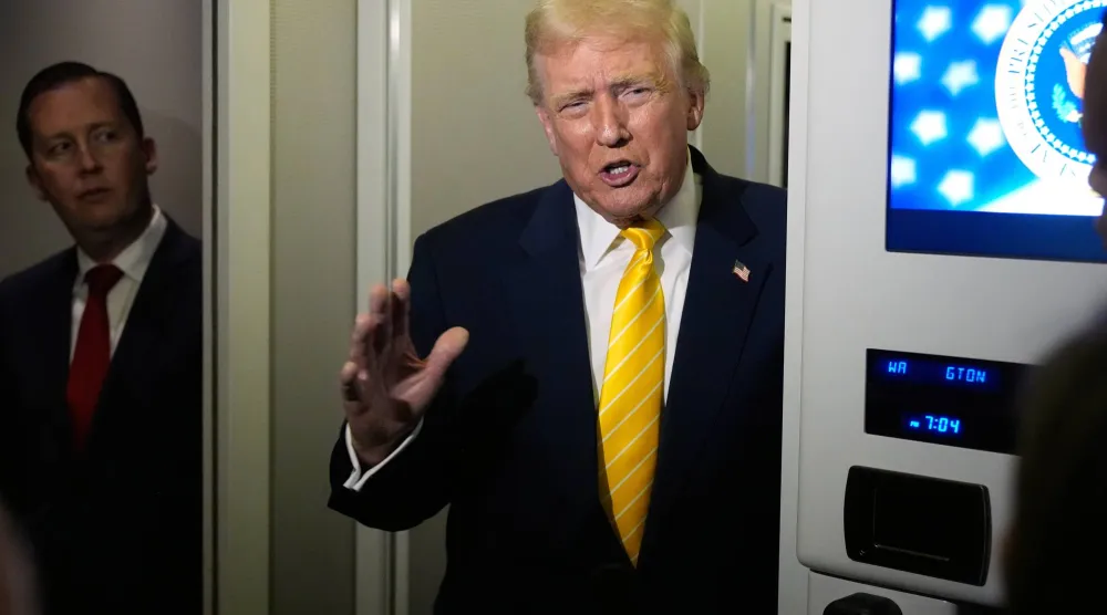 دونالد ترمب يتحدث إلى الصحافيين على متن الطائرة الرئاسية (أ.ب)