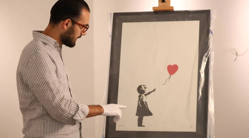 استعادة سريعة لعمل بانكسي الأشهر (رويترز)