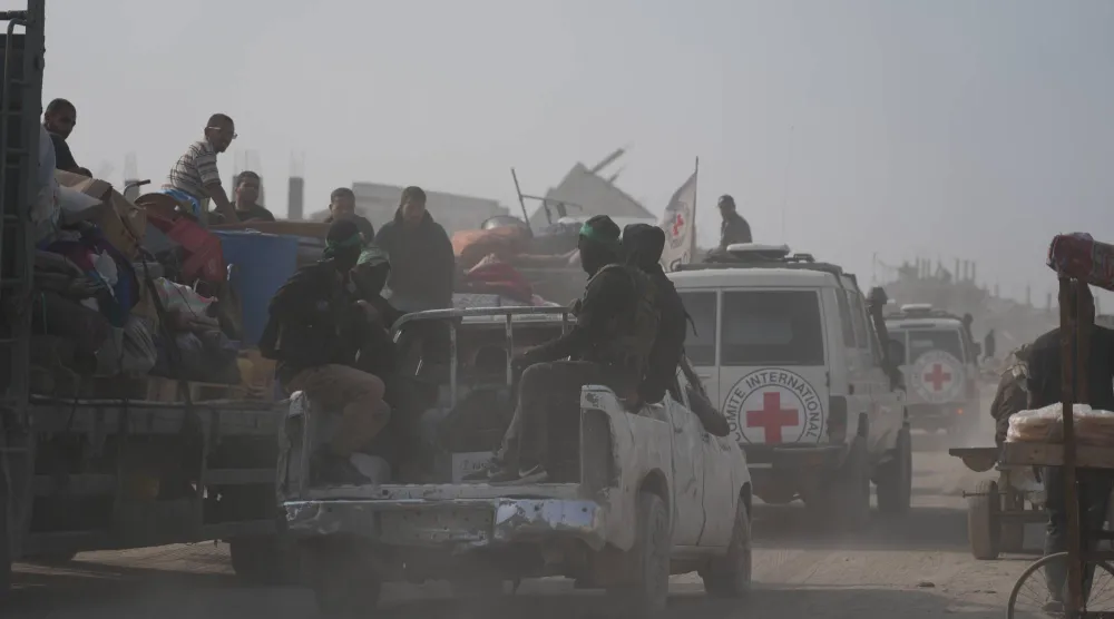 مسلحون من حركة «حماس» يتوجهون برفقة أعضاء اللجنة الدولية للصليب الأحمر إلى شرق مدينة غزة للبحث عن جثث الرهائن (أ.ب)