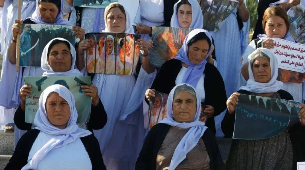 نساء إيزيديات يرفعن لافتات خلال مظاهرة تطالب بحقوقهن والإفراج عن المختطفين لدى تنظيم «داعش» المتطرف في الموصل بالعراق... 3 يونيو 2024 (رويترز)