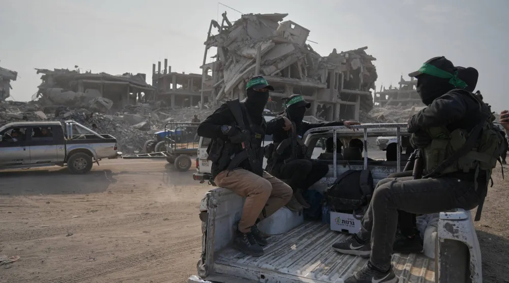 مسلحون من «حماس» برفقة أعضاء من اللجنة الدولية للصليب الأحمر يتوجهون إلى شرق مدينة غزة للبحث عن جثث الرهائن الخميس الماضي (أسوشييتد برس)