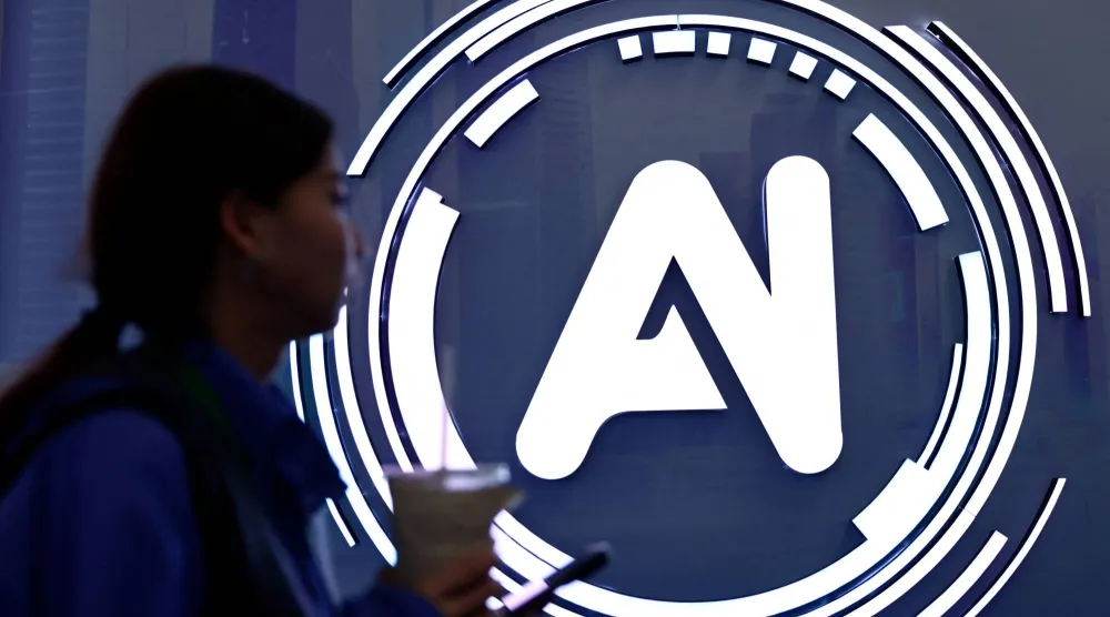 سيدة تمر بجوار لافتة كتب عليها «الذكاء الاصطناعي» في معرض حول الإنترنت بالصين (رويترز)