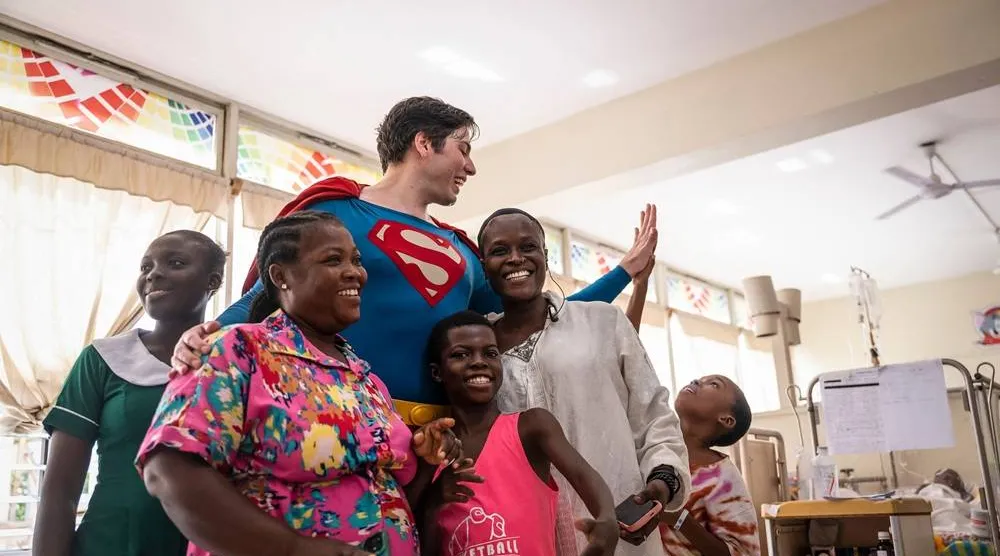  Leonardo Muylaert, known as the "Brazilian Superman", poses with patients and their relatives during a visit at the Korle Bu Teaching Hospital in Accra, on November 14, 2025. (AFP)
