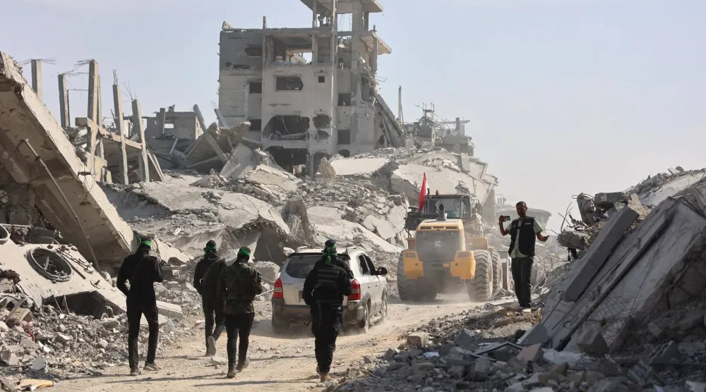 عناصر من «حماس» برفقة أعضاء من الصليب الأحمر الدولي يتبعون حفاراً بحثاً عن جثث الرهائن الإسرائيليين في غزة (أ.ف.ب)