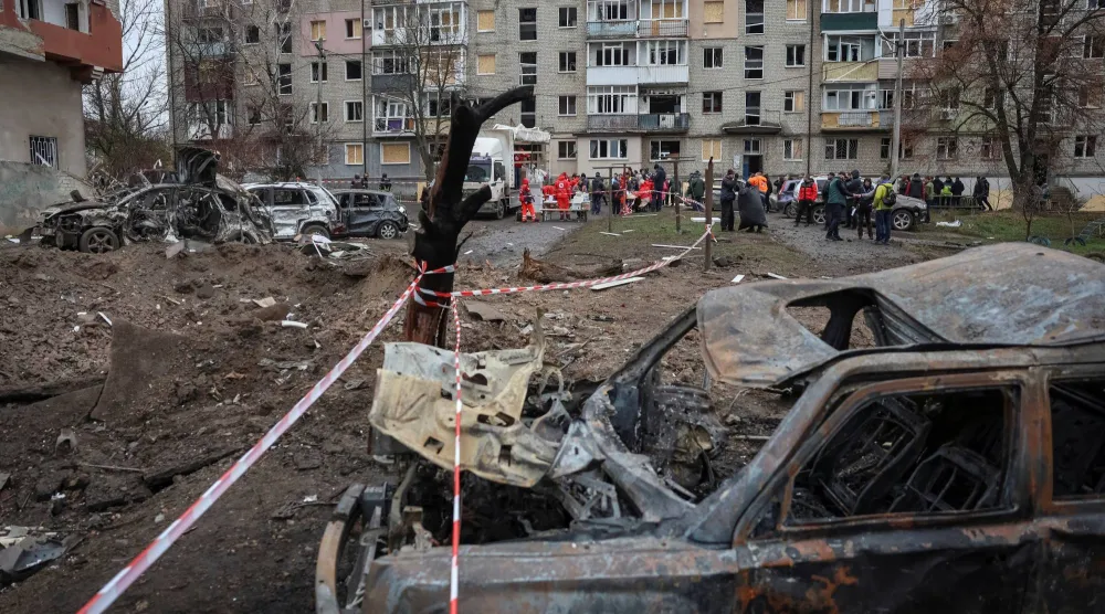 سكان يتلقّون مساعدات إنسانية بالقرب من مبنى شقتهم الذي تضرر خلال ضربات صاروخية روسية في بلدة بالاكليا في منطقة خاركيف بأوكرانيا في 17 نوفمبر 2025 (رويترز)