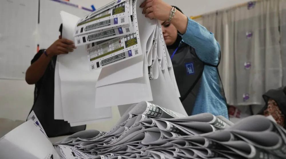 عاملون في الانتخابات يجمعون بطاقات الاقتراع للانتخابات البرلمانية بعد إغلاق صناديق الاقتراع في بغداد، العراق 11 نوفمبر 2025 (أ.ب)
