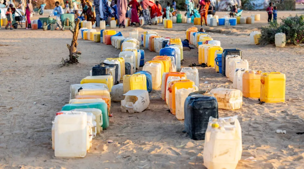 لاجئون سودانيون فروا من دارفور ينتظرون عند نقطة لتوزيع المياه في مخيم أوري كاسوني بتشاد (أ.ف.ب)